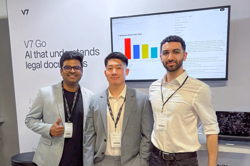 Three men in suits stand in front of GTCX banner and monitor.