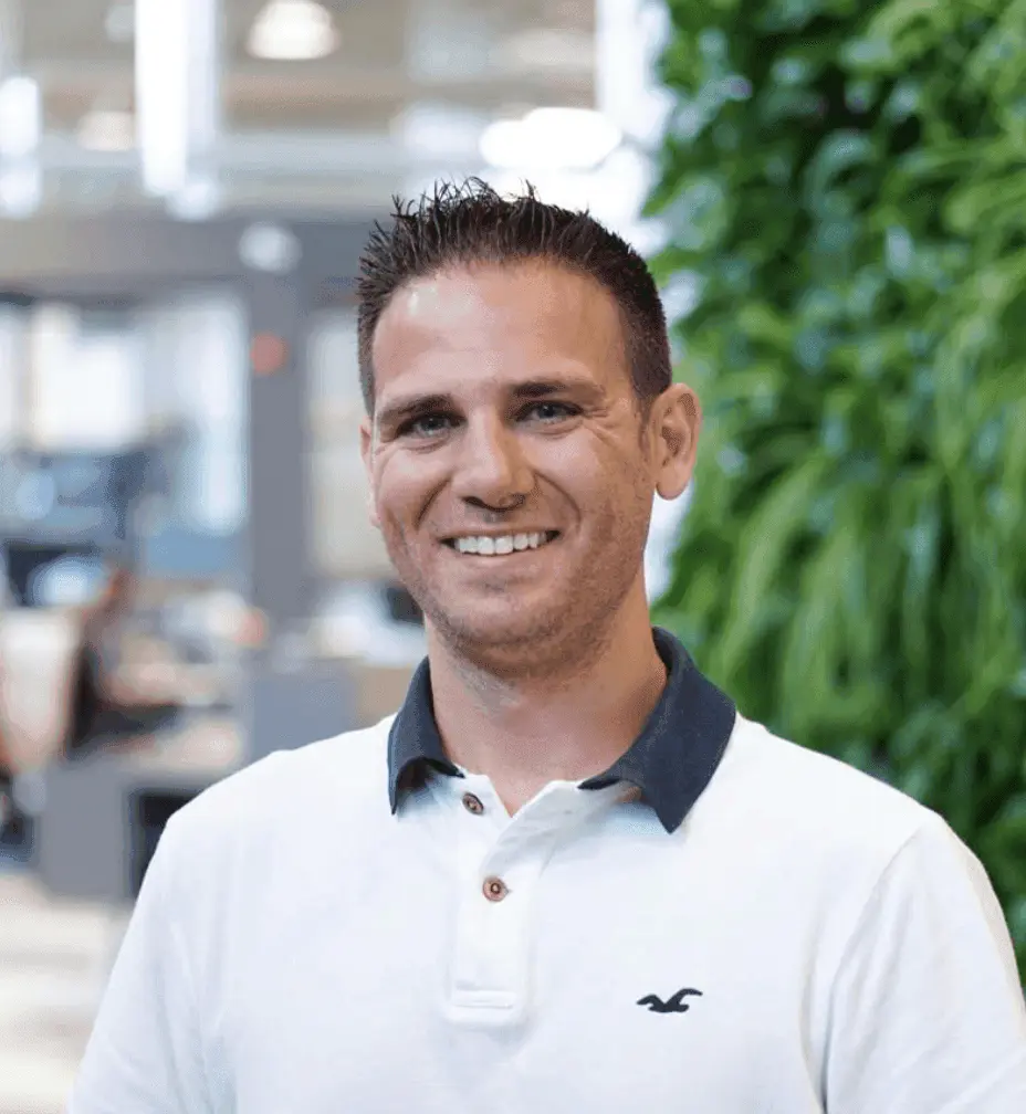 Man in white polo shirt smiling.