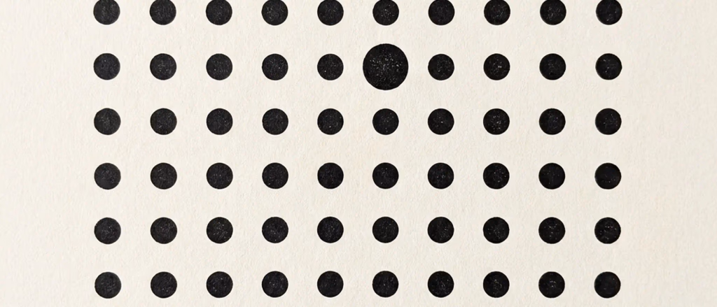 Grid of black dots with one larger, textured dot.