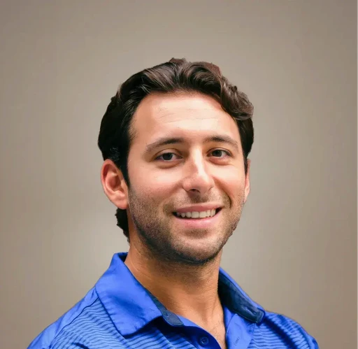 Man in blue polo shirt smiling.