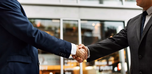 Two men in suits shaking hands.