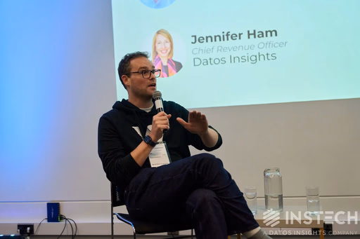 Man speaking into microphone with Jennifer Ham name on screen