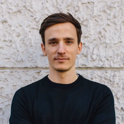 Man in black sweater against textured wall