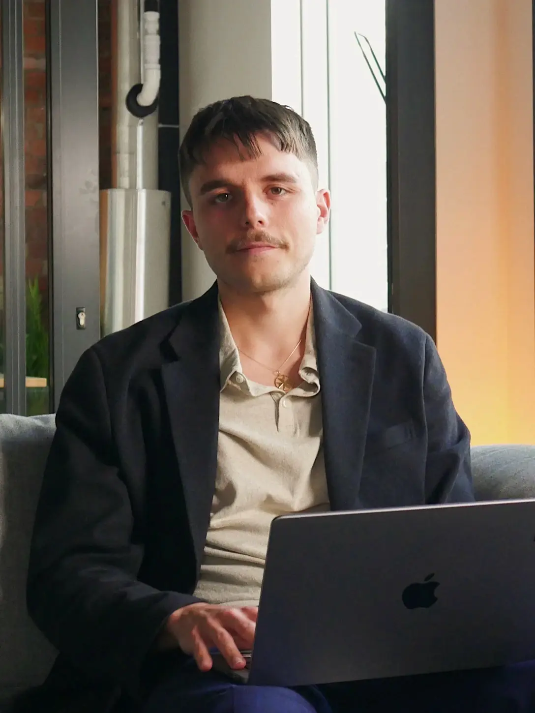 Man with mustache in blazer with laptop