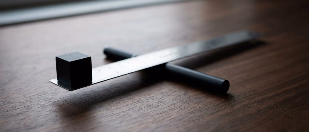Black cube on a ruler with black handles