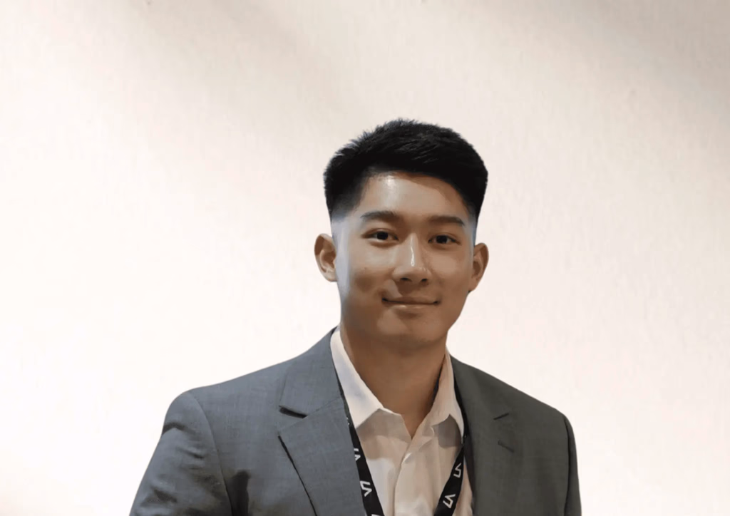 Man in suit and white shirt, smiling.