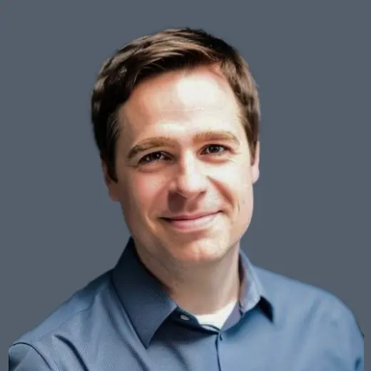 Man in blue collared shirt smiling