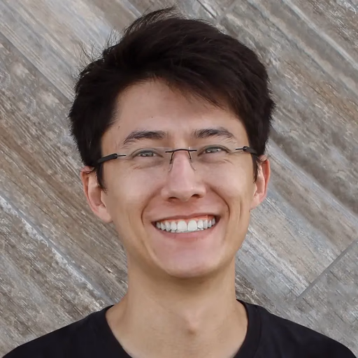 Man with glasses smiling broadly