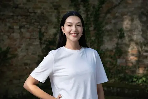 Woman in white t-shirt smiles at camera.