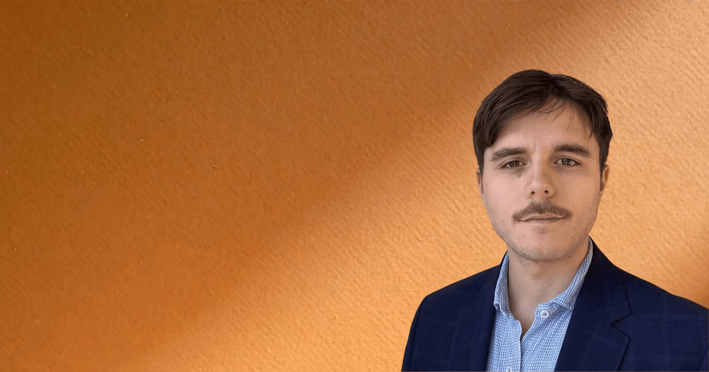 Man with mustache and navy jacket