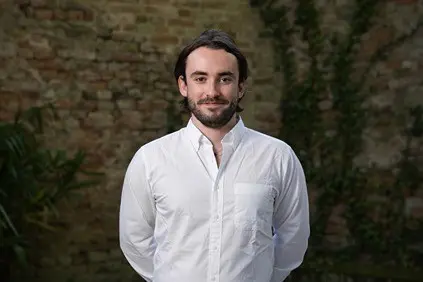 Man in white shirt smiles at camera