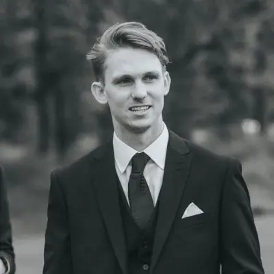 Man in suit and tie, smiling.