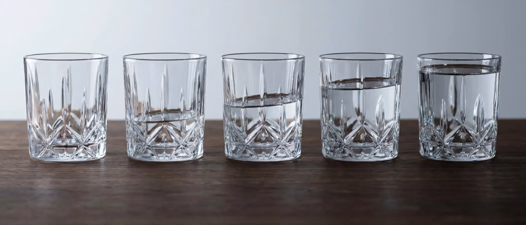 Five glasses with varying levels of water.
