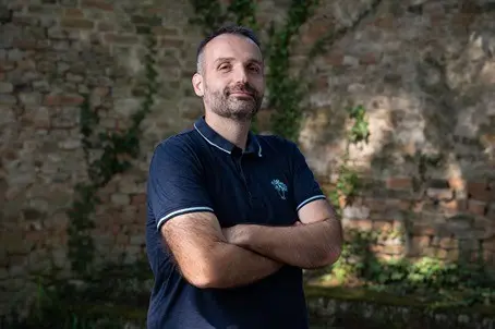 Man with crossed arms in dark polo shirt