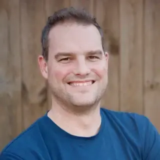Man smiling in blue t-shirt.