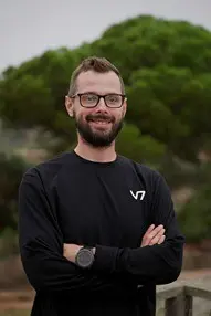 Man wearing glasses and a black shirt, outdoors.